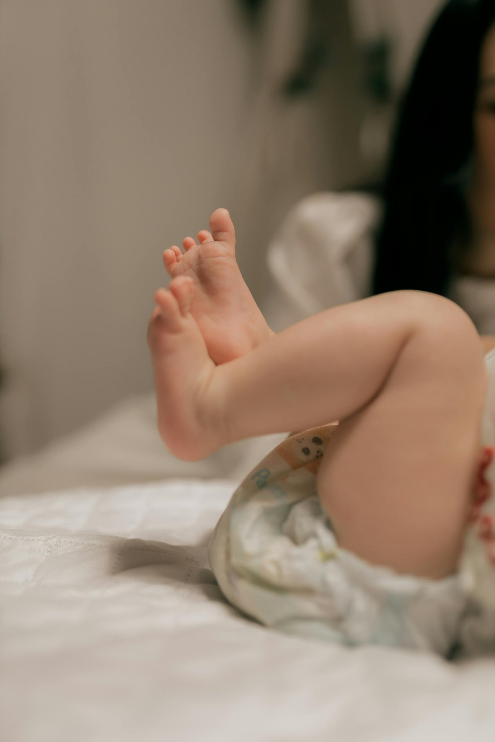 Close-up of a baby's feet on a soft bed, capturing innocence and warmth.