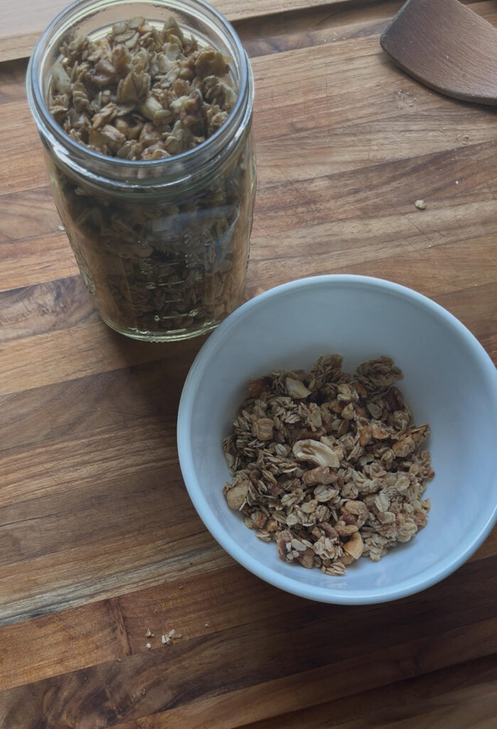 Homemade granola in a white bowl on a wooden counter