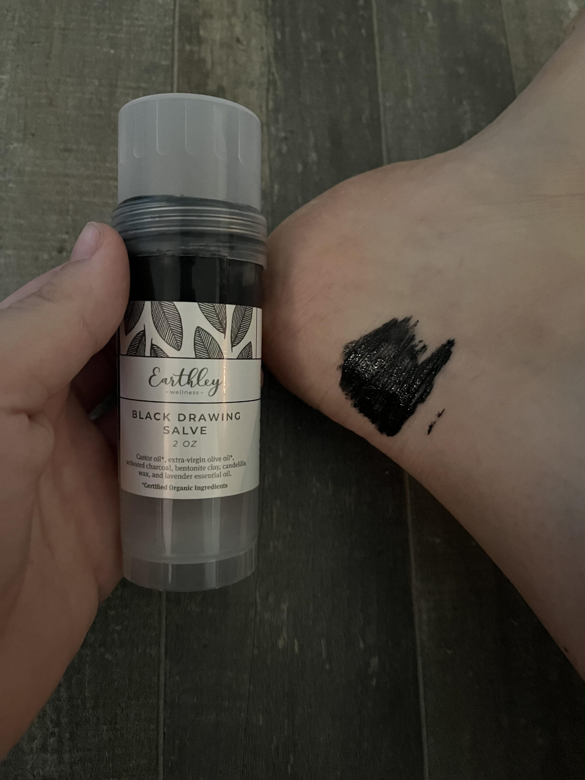 black drawing salve on foot drawing out bug bite sting sitting on floor to bring in diaper bag